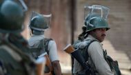 Indian paramilitary troopers watch Kashmiri protestors shout pro-freedom and anti-India slogans during a protest against civilian killings in Kashmir's ongoing summer unrest, in Srinagar on September 9, 2016. AFP / TAUSEEF MUSTAFA