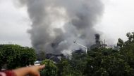  A woman points to a food and cigarette packaging factory on fire outside of Dhaka, Bangladesh, September 10, 2016. REUTERS/Mohammad Ponir Hossain