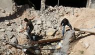 Men inspect a hole in the ground filled with water in a damaged site after airstrikes on the rebel held Tariq al-Bab neighbourhood of Aleppo, Syria September 24, 2016. REUTERS/Abdalrhman Ismail