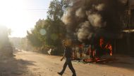  A Syrian man walks past a bus set ablaze following a reported air strike in the rebel-held Salaheddin district of Aleppo on September 25, 2016. The UN Security Council met for urgent talks as Syrian and Russian warplanes pounded rebel-held east Aleppo in