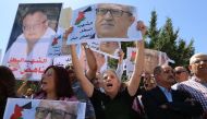 Protesters shout slogans and hold portraits of prominent Jordanian writer Nahed Hattar, who was shot dead the previous day outside an Amman court, during a demonstration in front of the prime minister's offices on September 26, 2016.  AFP / Khalil MAZRAAW