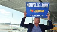 Ryanair chief executive Michael O'Leary gestures as he holds a sign reading 'New lines' during a press conference on new flights from Toulouse at the Toulouse-Blagnac airport on September 27, 2016. (AFP / Remy GABALDA)