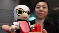 A Toyota employee displaying the company's new communication robot 'Kirobo Mini' during a press preview in Tokyo.(AFP / TOSHIFUMI KITAMURA)