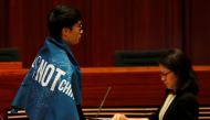 Newly-elected lawmaker Baggio Leung wears a banner 