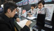 Customers return their Samsung Note 7 mobile phones at a dealership in Seoul on October 13, 2016. AFP / YONHAP / Yonhap / South Korea Out