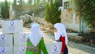 Children carrying food packets provided by Qatar Charity (QC) in Aleppo.