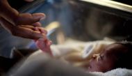 A man touches his newborn baby born three days earlier at the Israeli hospital in Port-au-Prince, January 20, 2010. (REUTERS / Carlos Garcia Rawlins)