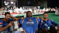 Pakistan Super League (PSL) team Karachi Kings player Chris Gayle (C) holds team shirt during second edition of PSL draft in Dubai on October 19, 2016.
PSL which will be held in United Arab Emirates in February-March 2017. (AFP / Aamir Qureshi)