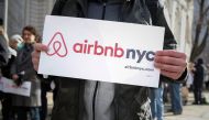 Supporters of Airbnb stand during a rally before a hearing called 