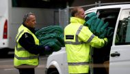 Border force officials carry blankets used by child migrants as they were brought by coach from 