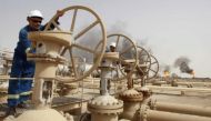 File picture of workers adjusting the valves of an oil pipe in Zubair oilfield in Basra, Baghdad. Reuters