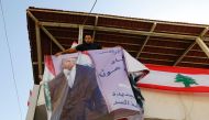 A supporter of Lebanese presidential candidate Michel Aoun puts up a portrait of him ahead of a parliament session expected to elect the ex-general as president and end a political stalemate of more than two years, as they gather in Jdeidah, on the northe