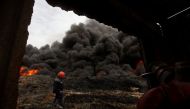 Smoke rises from oil wells, set ablaze by Islamic State militants before fleeing the oil-producing region of Qayyara. File photo. Image by: ALAA AL-MARJANI / REUTERS.