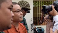 This photo taken on June 8, 2016 shows senator Hong Sok Hour (2nd L) from the Cambodia National Rescue Party (CNRP) being escorted by police at the Supreme Court in Phnom Penh. AFP / TANG CHHIN SOTHY