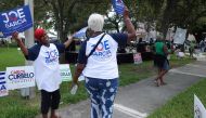 People confer during an event called 'Souls to the Polls' on November 6, 2016 in Cutler Bay, Florida, which aims to encourage minority voter turnout in the key swing state of Florida. Experts say black and Hispanic turnout is surging as many hope to keep 