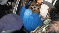 Officials escort Sharbat Gula (C), the green-eyed Afghan woman who became a symbol of her country's wars 30 years ago when her photo as a girl appeared on the cover of National Geographic magazine, as she enters a car to leave a hospital in Peshawar, Paki