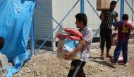 Beneficiaries carrying food items at a distribution centre in Mosul.