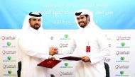 Faisal Rashid Alfahidh (right), Executive Director for Operations Management at Qatar Charity, and Dr Mohammed bin Hamad Al Naimi, General Director at Almaha Medical, exchanging documents after signing the agreement.