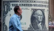 A man walks past a currency exchange bureau advertisement showing an image of the U.S. dollar in Cairo, Egypt, November 11, 2016. REUTERS/Mohamed Abd El Ghany
