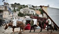 Mules transport goods from commercial ferry on the Greek island of Hydra, where cars are prohibited on November 12, 2016. (AFP / LOUISA GOULIAMAKI) 