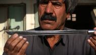 An Iraqi Kurdish man shows a knife engraved with a slogan in Arabic, 
