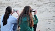 This file photo taken on November 27, 2015 shows women look at their cell phones at the Assateague Island National Seashore near Berlin, Maryland. AFP / KAREN BLEIER