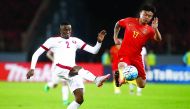 Cao Yunding of China (right) competes for the ball with Mohamed Musa of Qatar during their 2018 FIFA World Cup qualifying match in Kunming, in China's Yunnan province, yesterday. The match ended goalless. 