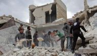 Rescuers and civilians inspect a destroyed building in the Syrian village of Kfar Jales, on the outskirts of Idlib, following air strikes by Syrian and Russian warplanes on November 16, 2016.  AFP / Omar haj kadour