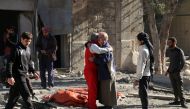 Syrians comfort each other on November 19, 2016 following a reported air strike on Aleppo's rebel-held neighbourhood of Bab al-Nayrab. Intense government air strikes and artillery fire killed at least 27 people in rebel-held parts of Syria's Aleppo, where