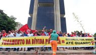 FILE PHOTO: Members of the Frente Nacional de Luta Campo e Cidade protest in front of the Central Bank of Brazil in Brasilia against the payment of the public debt by the government on March 31, 2016. (AFP)