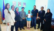 Andrea Baggayan (fifth left), the first beneficiary of 'Send Someone Home' programme, receives her ticket and pocket money at POLO-OWWA office. Also seen are Philippine Labour Attache David Des Dicang (fourth left), UFOQ Chairman Ressie S Fos (second righ