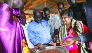 Yasime Sooka, a member of the UN Commission on Human Rights, is shown a common staple of Sorghum by community leaders of the UN Protection of Civilians (PoC) site in Juba, South Sudan, yesterday. A group of three commissioners and their teams arrived in t