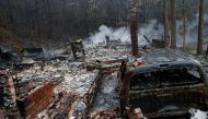 GATLINBURG, TN - NOVEMBER 30: The remains of a home smolder in the wake of a wildfire November 30, 2016 in Gatlinburg, Tennessee. / AFP.