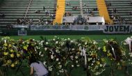 A woman places flowers before a mourning ceremony for victims after a plane carrying Brazil's soccer team Chapecoense crashed in Colombia, at Arena Conda stadium in Chapeco, Brazil, December 2, 2016. REUTERS/Diego Vara