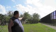 Ernest Villarreal points to where the U.S. border fence passes through the backyard of his family's home in Brownsville, Texas, U.S. on November 18, 2016. REUTERS/Jon Herskovitz