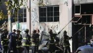 Firefighters work to clear the debris from a doorway following an overnight fire at a warehouse in the Fruitvale neighbourhood on Saturday in Oakland, California. (AFP photo).
