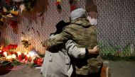 Rachel Saxer (L) embraces friend La Tron at a makeshift memorial near the scene of a fatal warehouse fire in the Fruitvale district of Oakland, California, U.S. December 4, 2016. / STEPHEN LAM / REUTERS.