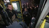 Syrian residents of the Old City of Aleppo stand in a bus at a crossing point during their evacuation to a distinct government-controlled area of the city early on December 7, 2016.  AFP / Youssef KARWASHAN
