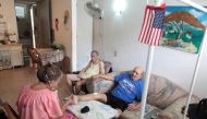 Juanita Gomez Cruz (L) cleans her husband Pedro after he suffered a foot amputation several years ago as their son Dafner sits next to them at their home, in San Juan, Puerto Rico, November 15, 2016. Picture taken November 15, 2016. REUTERS/Alvin Baez