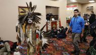 A Native American dancer walks past activists and veterans who are sheltering at the Prairie Knights Casino because of a blizzard hitting the Standing Rock Indian Reservation, near Fort Yates, North Dakota, U.S., December 6, 2016. REUTERS/Lucas Jackson