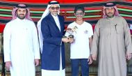 Minister of Culture and Sports H E Salah bin Ghanem Al Ali presents the winner's trophy to Saeed Hamad Saeed Juma during the presentation ceremony.