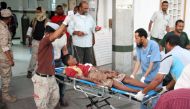 Graphic content / A wounded Yemeni man arrives at a hospital on December 10, 2016 after a suicide bomber killed 35 soldiers and wounded around 50 others at a military camp in Yemen's southern city of Aden. / AFP / SALEH AL-OBEIDI