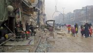 Syrian pro-regime fighters gesture as residents, fleeing violence in the restive Bustan al-Qasr neighbourhood, arrive in Aleppo's Fardos neighbourhood on December 13, 2016, after regime troops retook the area from rebel fighters. Syrian rebels withdrew fr