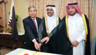 H E Dr Mohammed bin Saleh Al Sada, Minister of Energy & Industry (centre) and Ibrahim Fakhroo (right), Director of Protocol at the Foreign Ministry, cutting cake with Seiichi Otsuka, Japanese Ambassador to Qatar, during Japan Independence Day celebrations