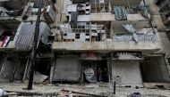 Boys stand amid the damage in the government-held al-Shaar neighborhood of Aleppo, during a media tour, Syria December 13, 2016. REUTERS/Omar Sanadiki
