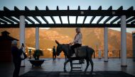 British women take photos of themselves with a statue of a burro taxi (donkey taxi) during their holidays in Mijas, near Malaga, southern Spain, November 15, 2016. Picture taken November 15, 2016. REUTERS/Jon Nazca