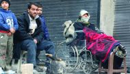 People warm themselves around a fire while waiting to be evacuated from a rebel-held sector of eastern Aleppo in Syria yesterday. 