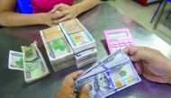 A money changer handles a transaction of US dollar and Myanmar Kyats at the Myanmar Central Bank.