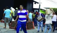 People carry goods taken from a food wholesaler after it was broken into, in La Fria, Venezuela, yesterday.