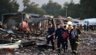 Rescue workers search amid the debris left by a huge blast that occured in a fireworks market in Mexico City, on December 20, 2016 killing at least 26 people and injuring scores. AFP / RONALDO SCHEMIDT
